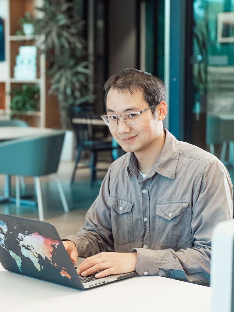 A Man in Gray Sleeves Using a Laptop